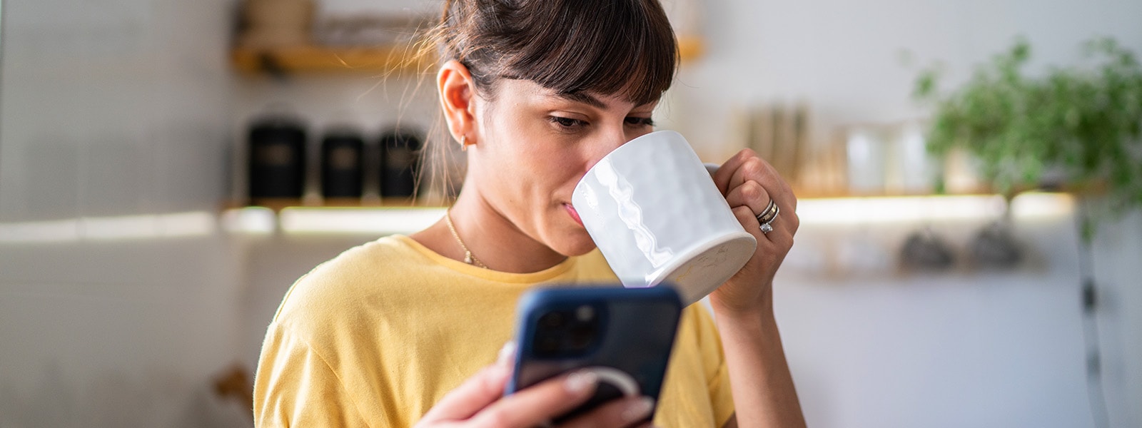 A woman drinks coffee and looks at her phone wondering what is a third party app.