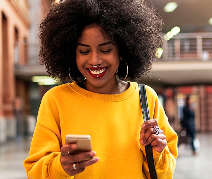 A person looking at their phone, trying to figure out why their battery is draining so quickly.