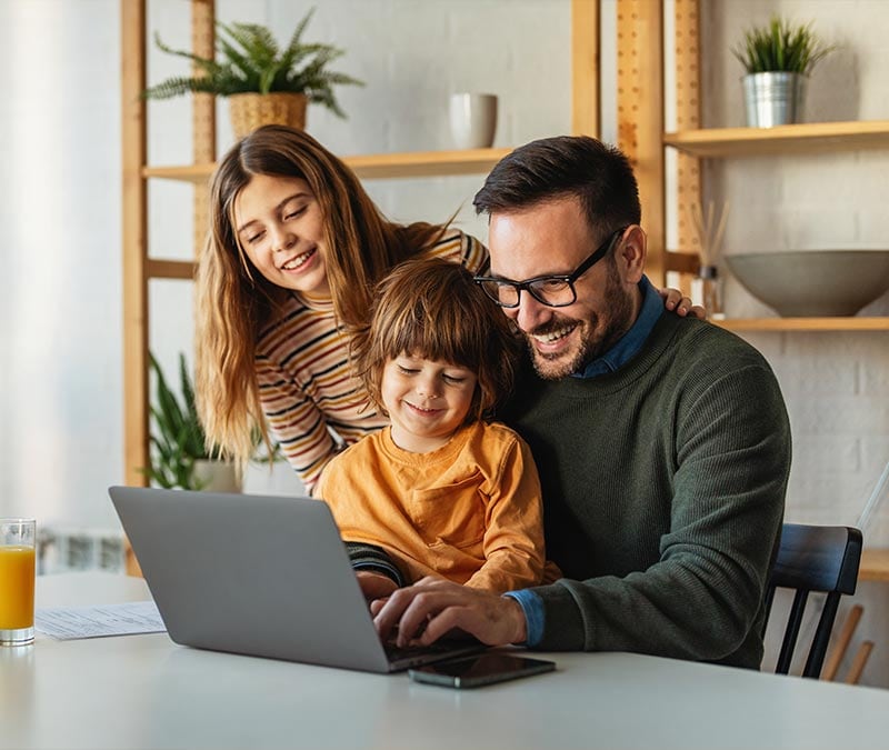 A father teaching his kids how to use their password manager on a laptop.
