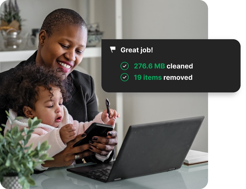 A woman with a toddler on her lap using Norton Utilities Ultimate on her PC.