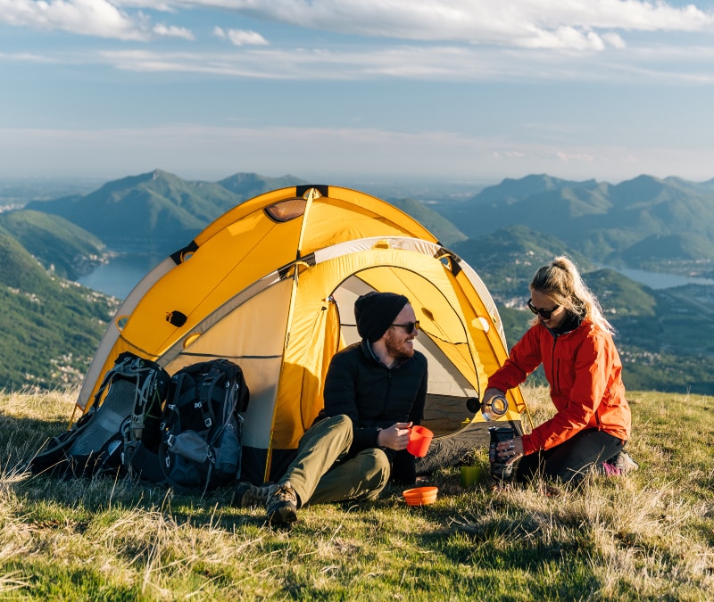 A couple camping and using wifi to connect to the internet.