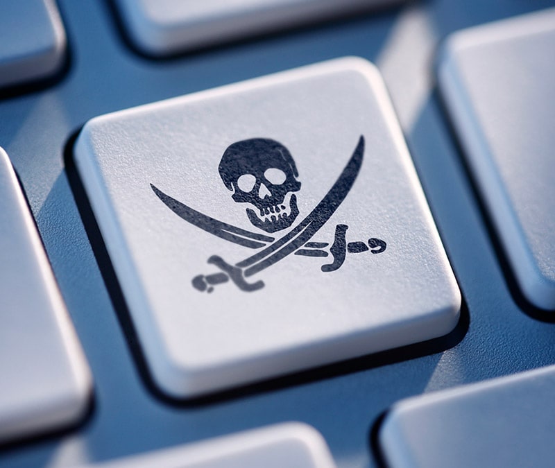 A computer key with a skull and swords pirate symbol representing the dangers posed by cracked VPNs.