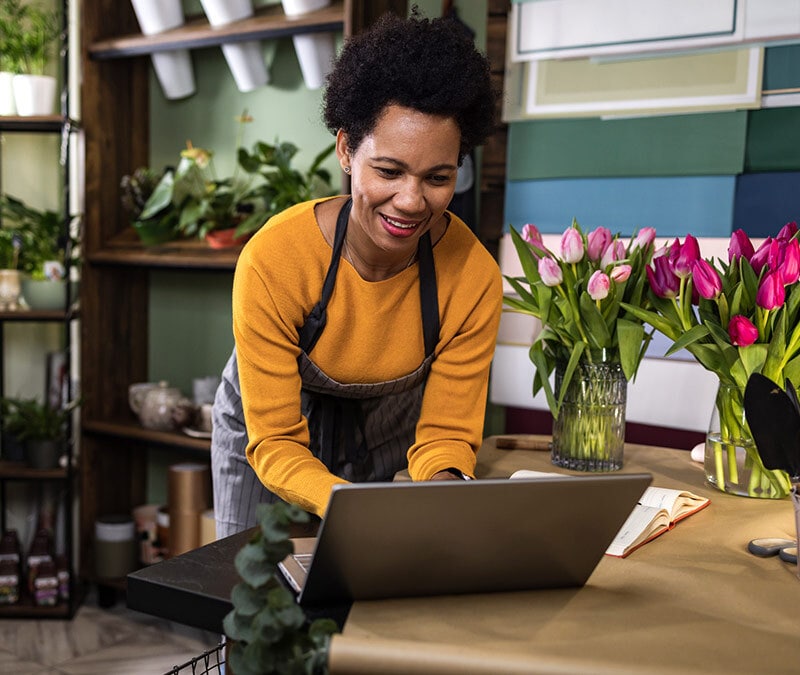 A flower shop small business owner using a laptop.