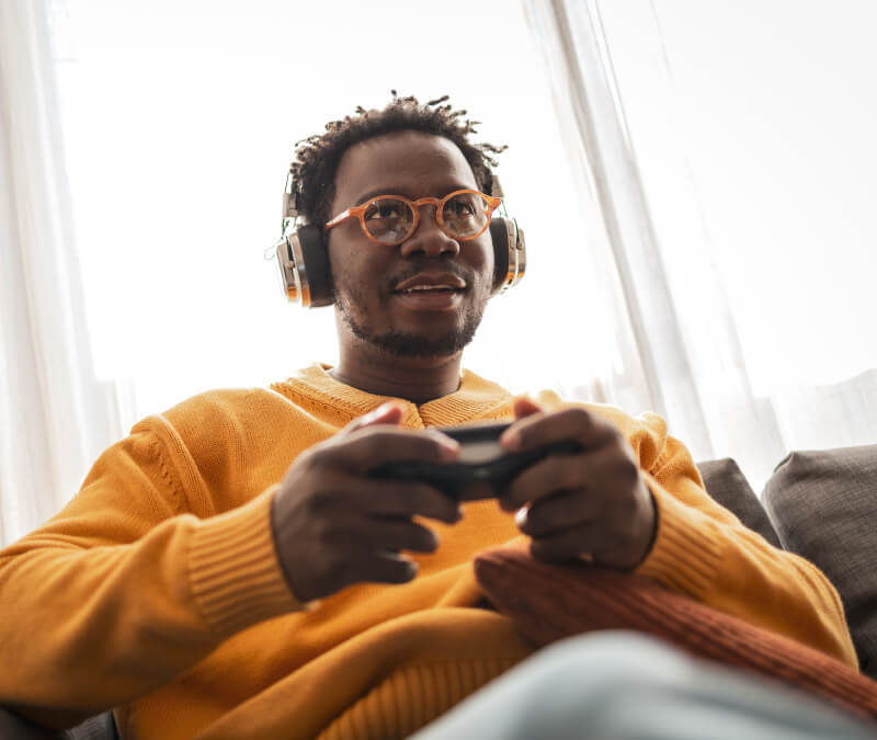 A woman putting on pink gaming headphones.