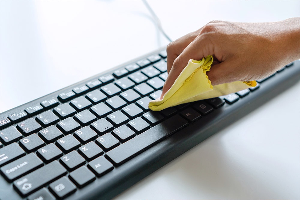  An image of someone wiping around they keys on a keyboard.