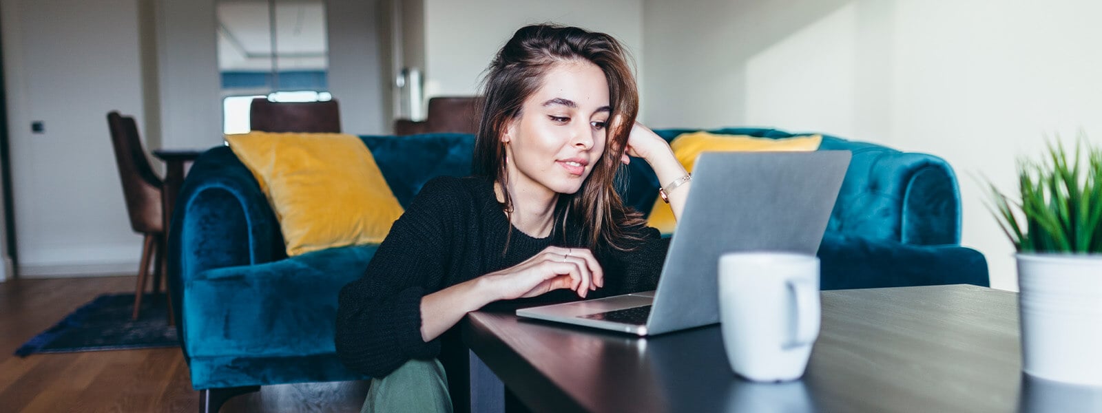 A woman sitting at a coffee table learning how to encrypt email.