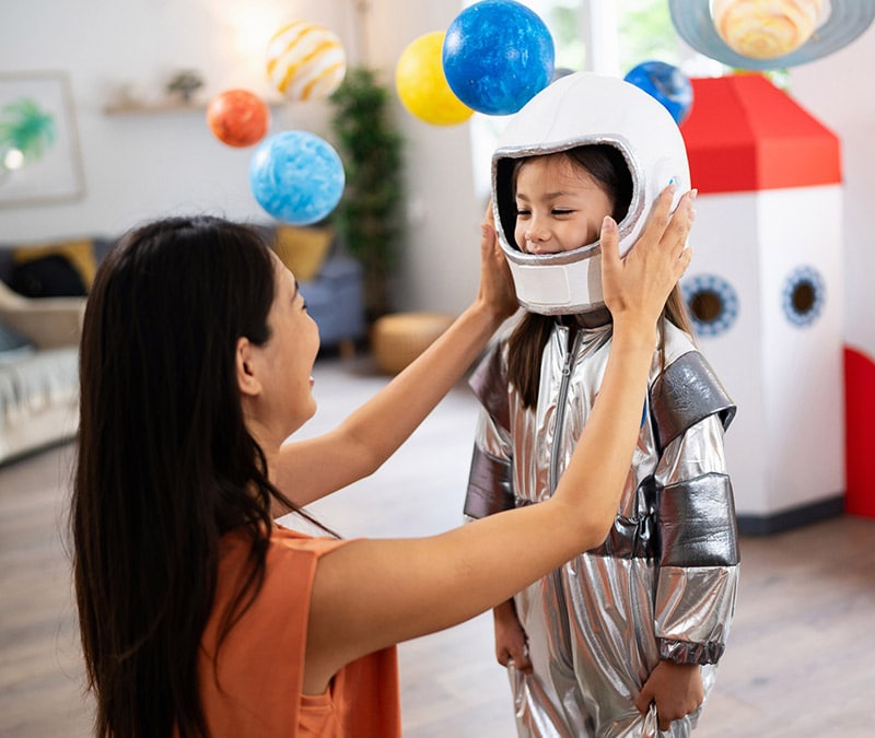 Someone putting a toy helmet on their child, representing how to protect personal information online.