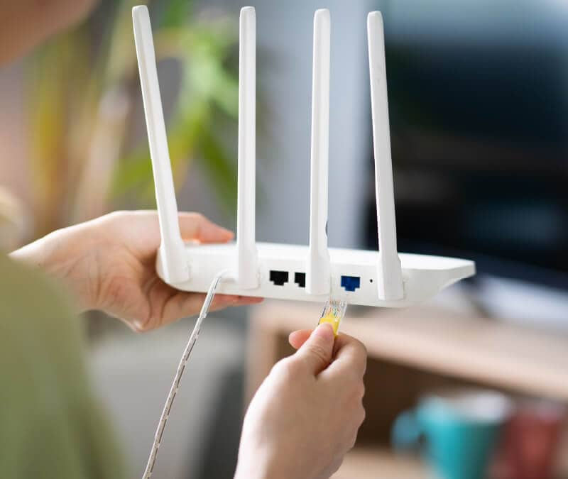 Person setting up a Wi-Fi router.