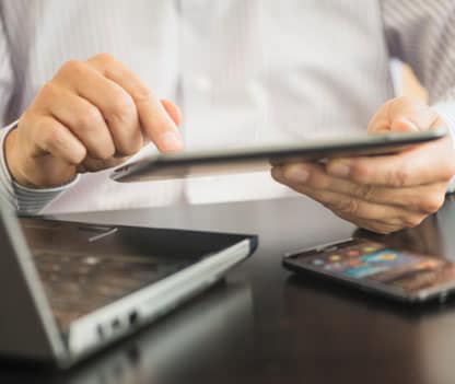 A man using a tablet to read a guide on how to stop spam texts.