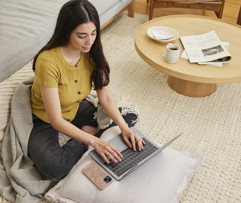 A woman using laptop to research ways to protect her smart speaker from hackers.