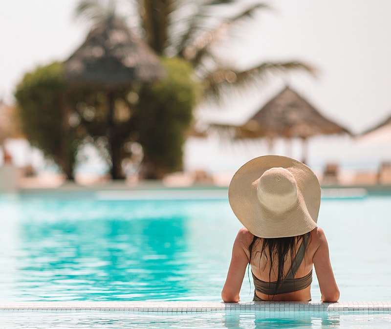 A woman in the pool of a resort she booked on Booksi.