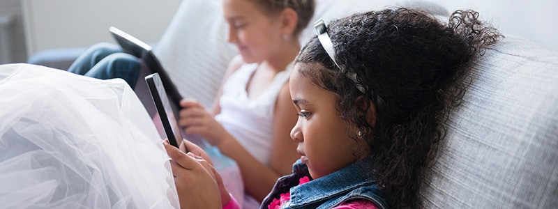 Children playing on mobile devices with parental controls enabled.