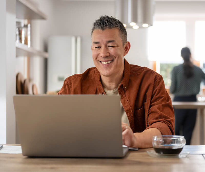 A person smiles at their laptop after learning how to lower their CPU usage.