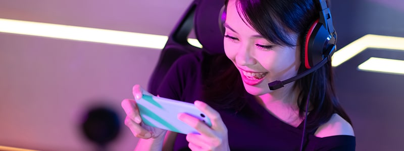 A person playing a mobile game, highlighting the potential risks of mobile gaming scams and how to protect yourself.