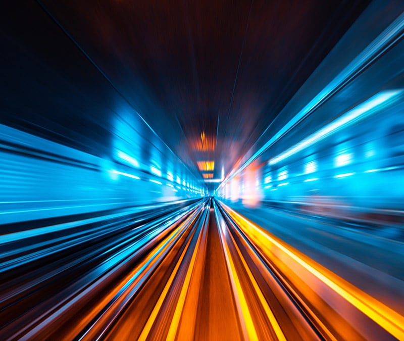Dynamic light streaks in a tunnel, symbolizing Norton VPN's high speed and smooth performance.