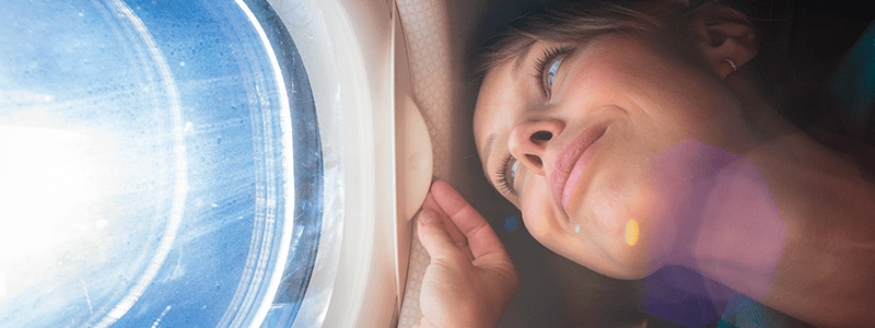 Woman bored on airplane wondering if it's safe to connect to the plane Wi-Fi.