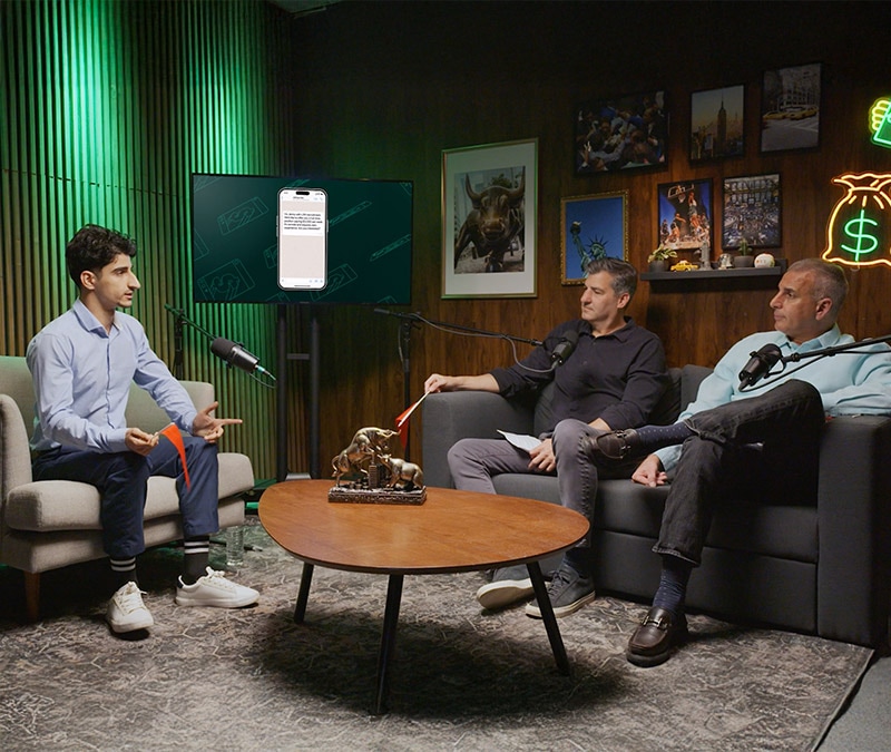 Three men with microphones sitting on couches in a studio; they’re discussing scams Gen Z is falling for on a new episode of “Generation Money.”