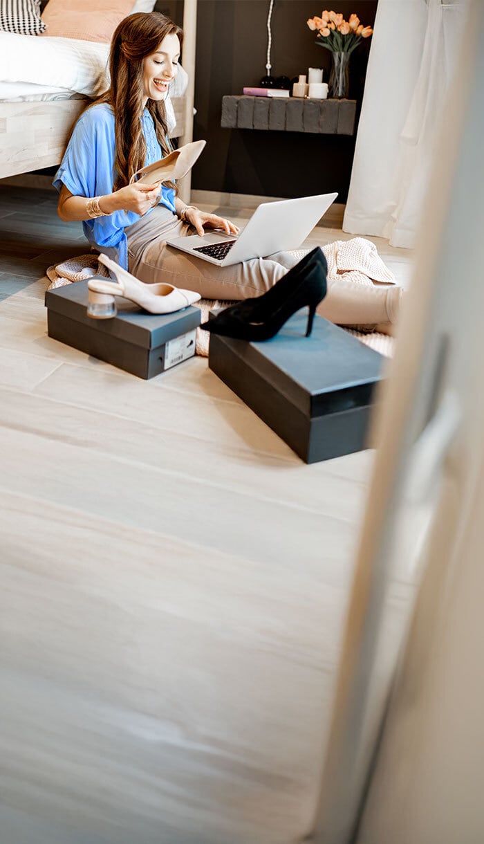 A woman happily shops online, knowing she's protected by Norton Scam Protection features.