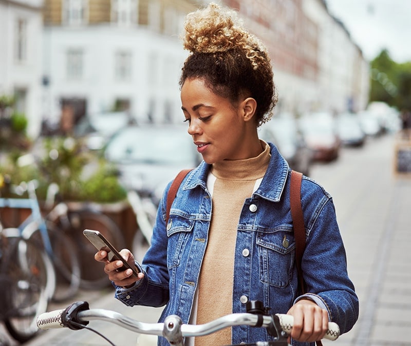 An image of a woman assessing a potential social media threat on her phone.