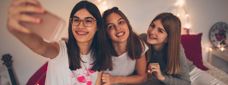 Three teenage girls taking a selfie - highlighting a potential risk for parents with teenagers and needing to know about online safety tips.