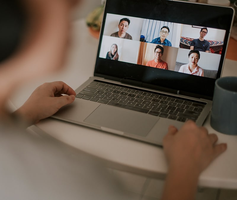 Someone talks with their friends via a laptop webcam