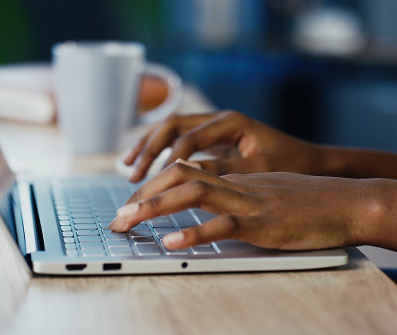 Woman typing on laptop wondering if her keystrokes are being logged.