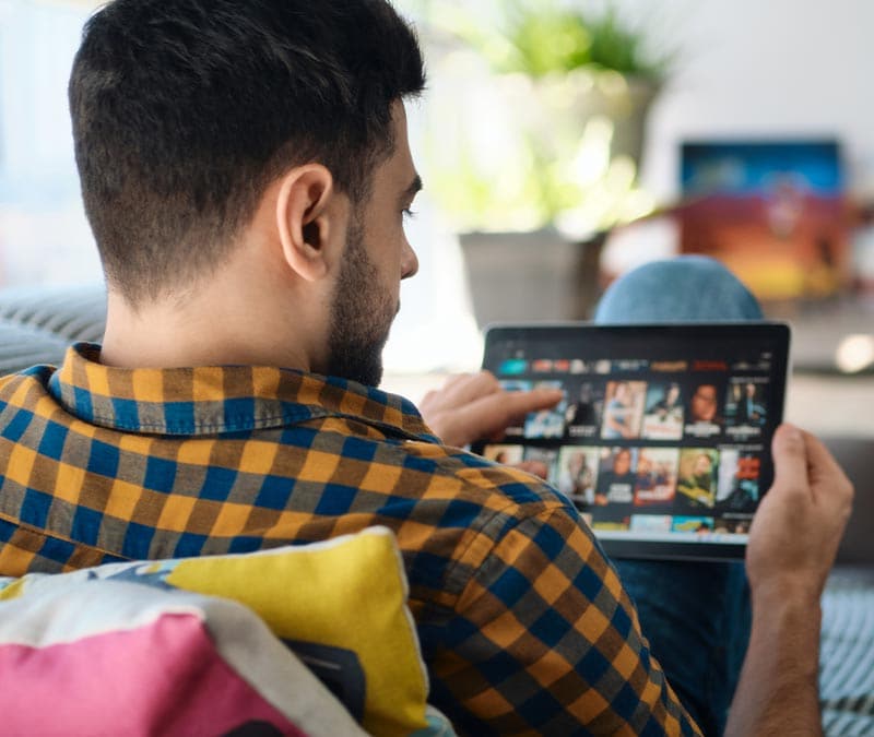 A man browses a catalog of movies on a video streaming service.