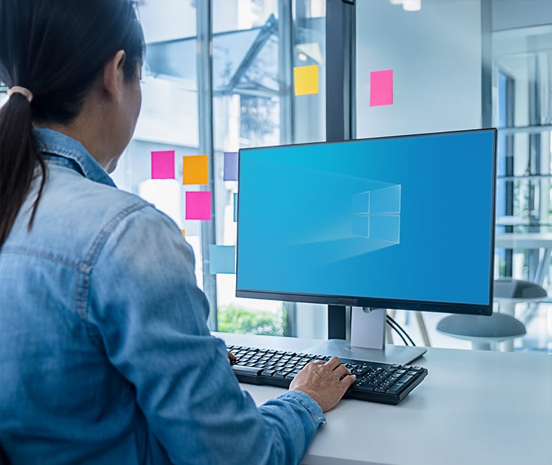 A woman upgrading her PC to Windows 11 because Windows 10 has reached its end of life.