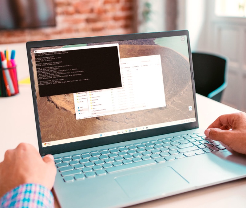 A person running the CHKDSK command on a laptop.