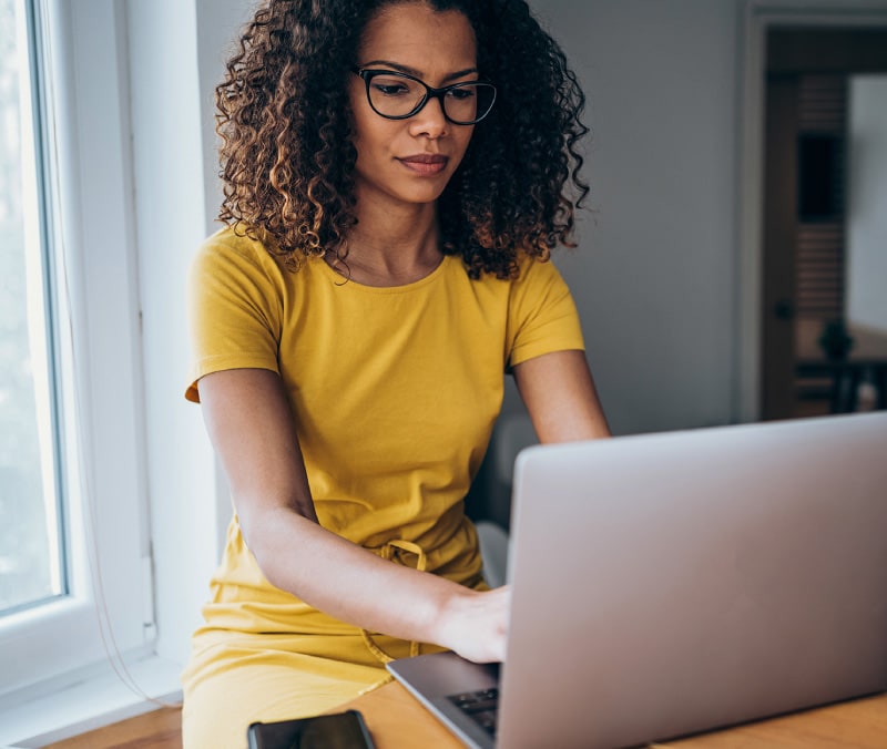 A woman learns about credential stuffing on her laptop.