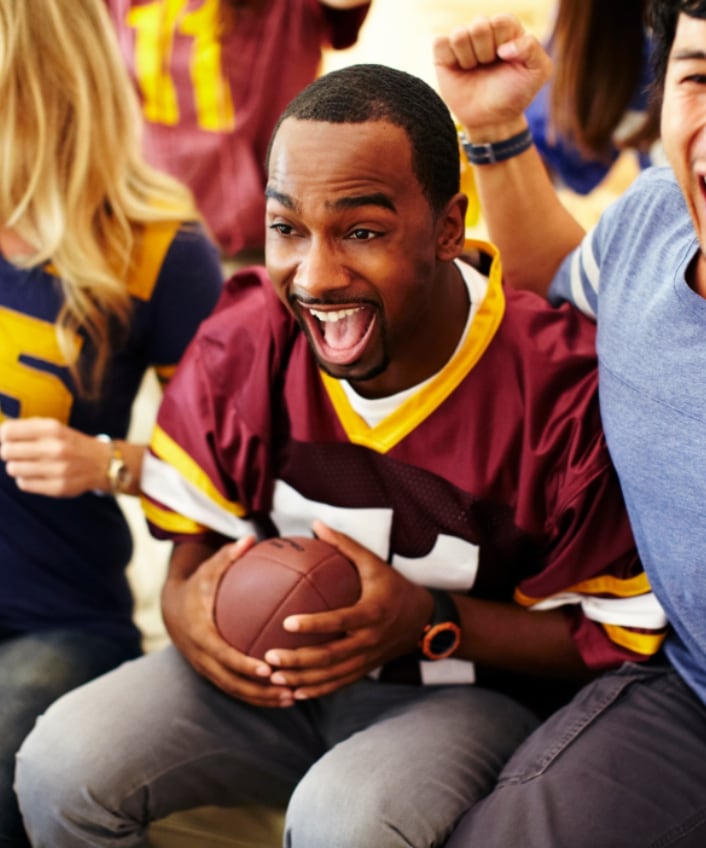 Football fans cheer as they watch their team, knowing they’re safer from cyber threats during football season.