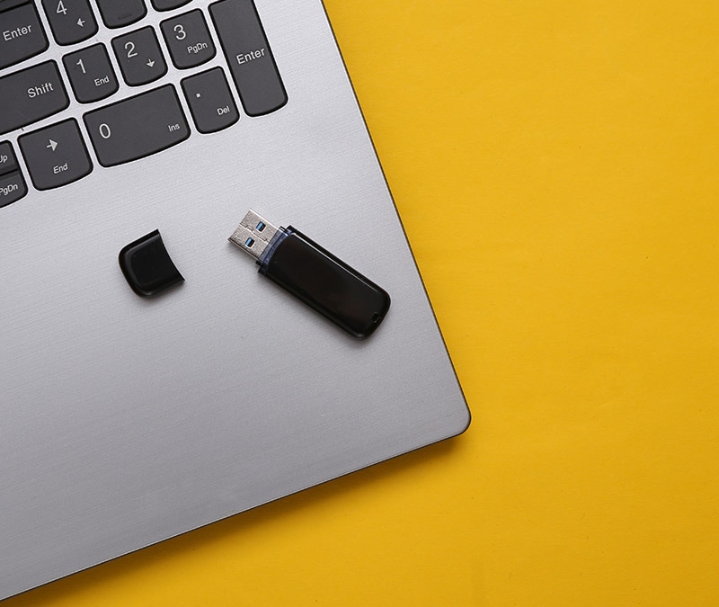 Image of a laptop with a flash drive.