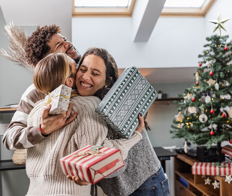 Friends and family sharing gifts after avoiding holiday shopping scams