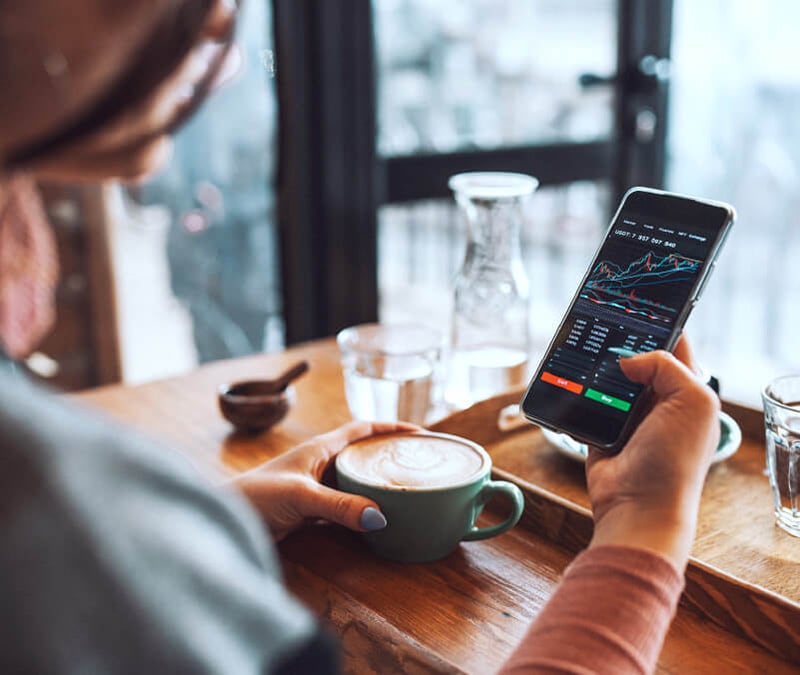 A woman checks stocks on her phone as a way of making money online.