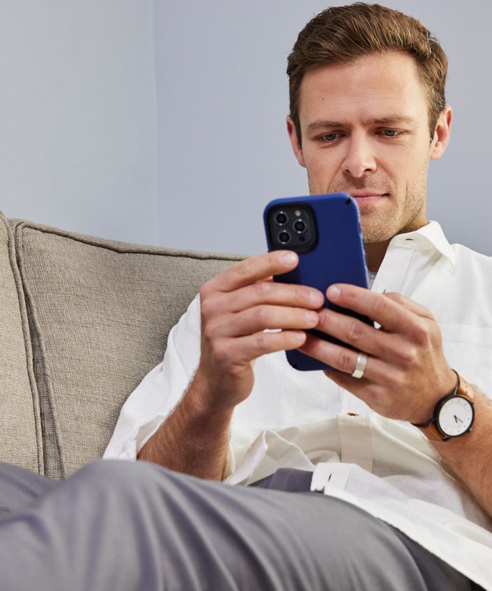 A man using a blue phone researching how to protect his online privacy with a no-log VPN.
