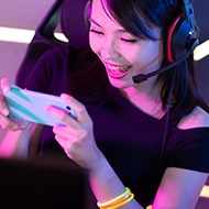 A person playing a mobile game, highlighting the potential risks of mobile gaming scams and how to protect yourself.