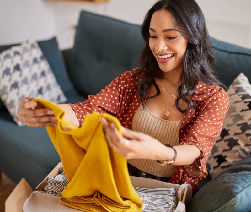 A woman opens a package from Poshmark.