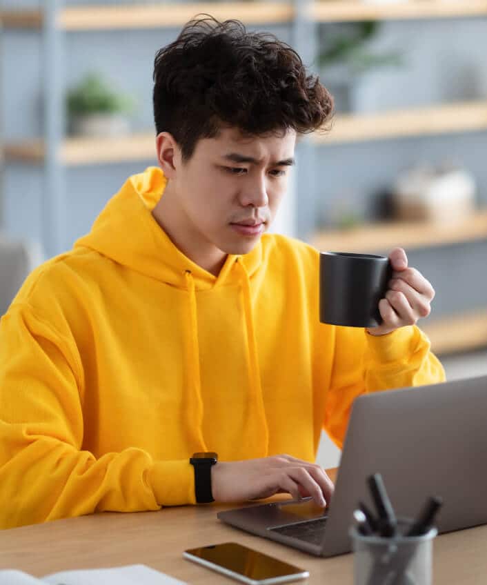 A man looking at his computer wondering if his device has spyware.