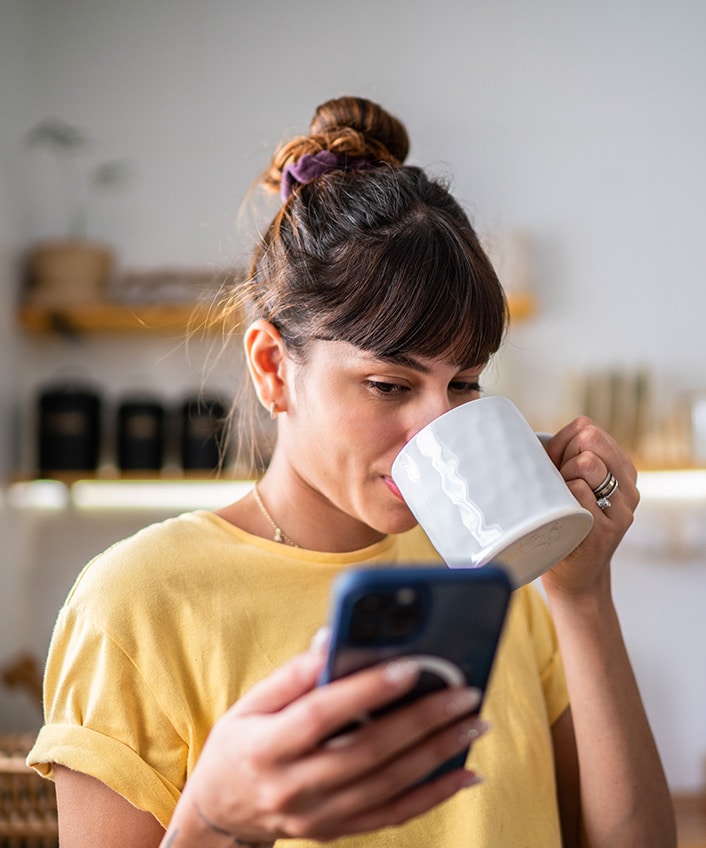 A woman drinks coffee and looks at her phone wondering what is a third party app.
