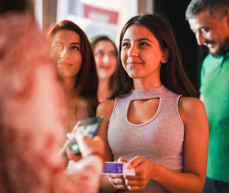 A happy woman in line for a concert moments before discovering she’s a Ticketmaster scam victim.