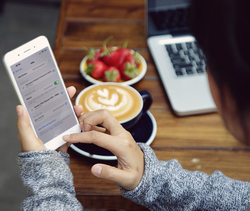 A person at a cafe turning off the VPN on her phone.