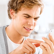 A person looking at their phone in confusion, trying to decipher the meaning of a strange text message with random letters and numbers.