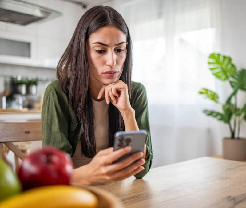 Image of a frustrated person looking at their phone