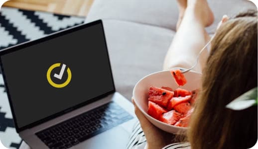 Woman having some watermelon on the couch.