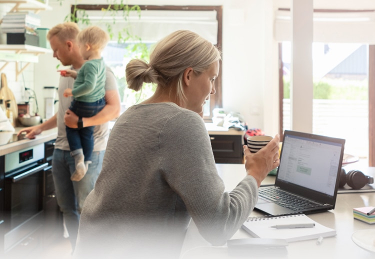 Mother using laptop while father cooking.