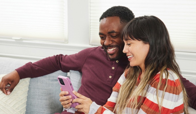 Man and woman looking at phone and smiling